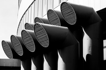 Black and white screensaver, duct pipes with grates on the background of the building.