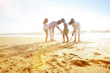 Family having fun writing messages on sandy beach