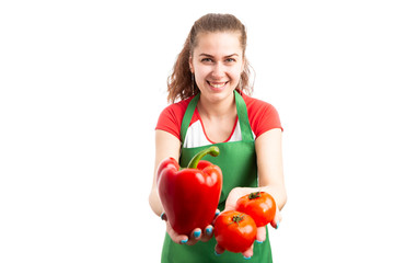 Woman supermarket or retail worker offering fresh vegetables.