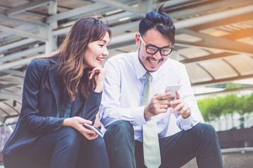 Business team working at city, looking a mobile phone