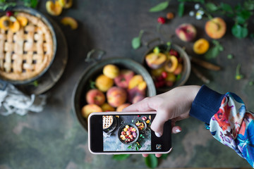 Hand making photo of  Fruit pie on colorful wooden rustic background
