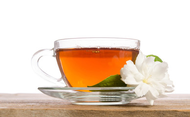 Glass cup of Tea with jasmine flowers on wooden table