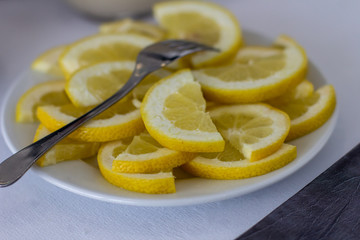 Sliced lemon halves lying on a white porcelain plate closeup