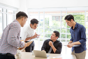 Businessman plaining data at meeting. Business people meeting around desk. Asian people. Young business man.