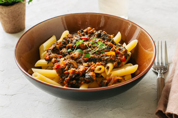 Tomato sauce ground beef pasta on a white stone background. Toned.
