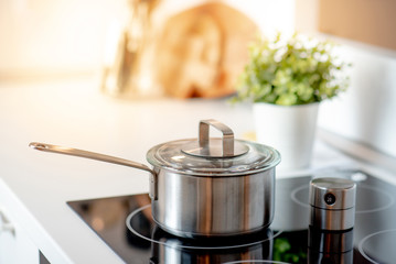 Stainless steel pot on electric stove with kitchen timer in modern kitchen. Cooking utensils concept - Powered by Adobe