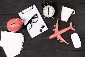 Top view of an office table with stationery and pink airplane