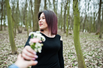 Portrait of brunette girl in black dress at spring wood.