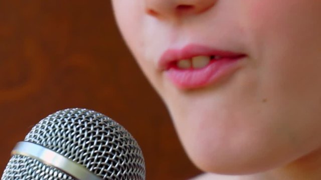 mouth of a child singing into a close-up microphone.