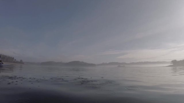 video of a lake in Portugal in a foggy sun rise on a 4 man kayak at high speed.
