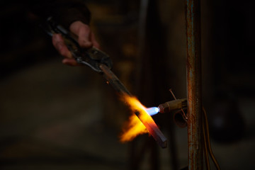 Treatment of molten metal on blurred background, close-up.