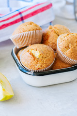 Gluten free almond flour muffins with apples in a bowl on a white stone background.