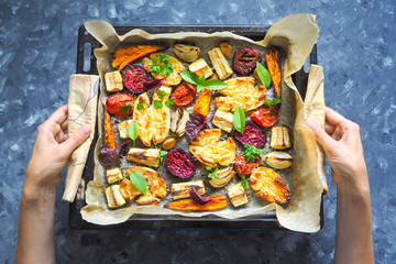 baked carrots, beets, potatoes, zucchini and tomatoes on a baking sheet, top view food