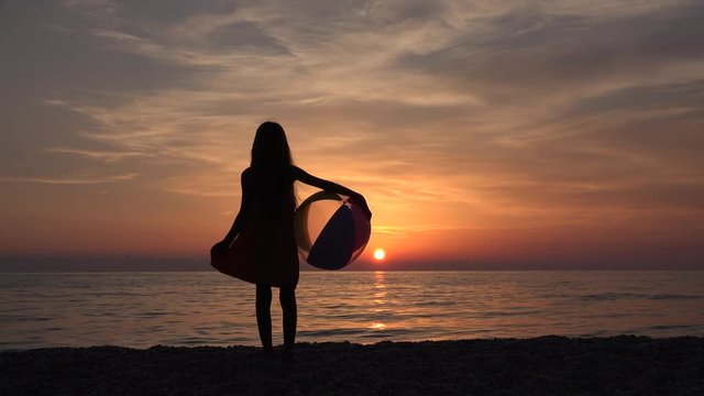 Child Playing Beach Ball in Sunset, Kid Watching Sea Waves, Girl View at Sundown