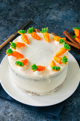 Homemade carrot cake with cream cheese frosting decorated with carrot marmalades. Close up.