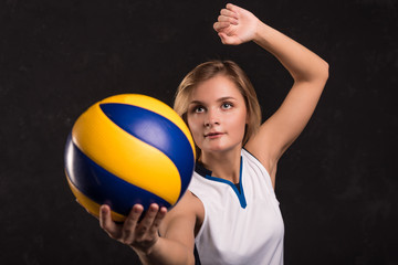 Girl playing volleyball on a dark background