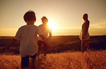 Happy family having fun playing at sunset on summer nature.
