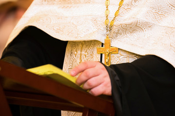 The priest says a prayer. The emphasis on the cross.