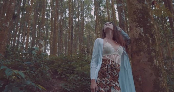 Beautiful brunette woman walking in hazy tropical mountain forest - video in slow motion