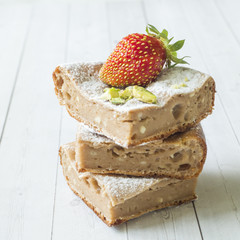 Cottage cheese casserole portion with strawberries and mint, pistachio nuts on a light background. concept of Breakfast