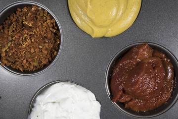 Soy sauce, balsamic sauce, pomegranate sauce, ketchup, sour cream, mustard, basil, pepper in kitchen utensils