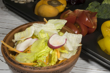 salad in a salad bowl of vegetables is on the background of fruits and vegetables