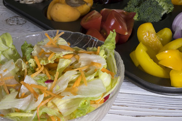salad in a salad bowl of vegetables is on the background of fruits and vegetables