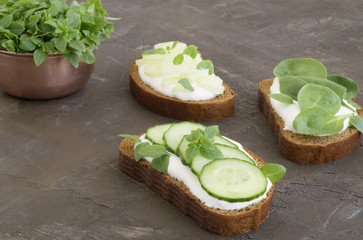 Bread with yogurt and cucumber on brown background.