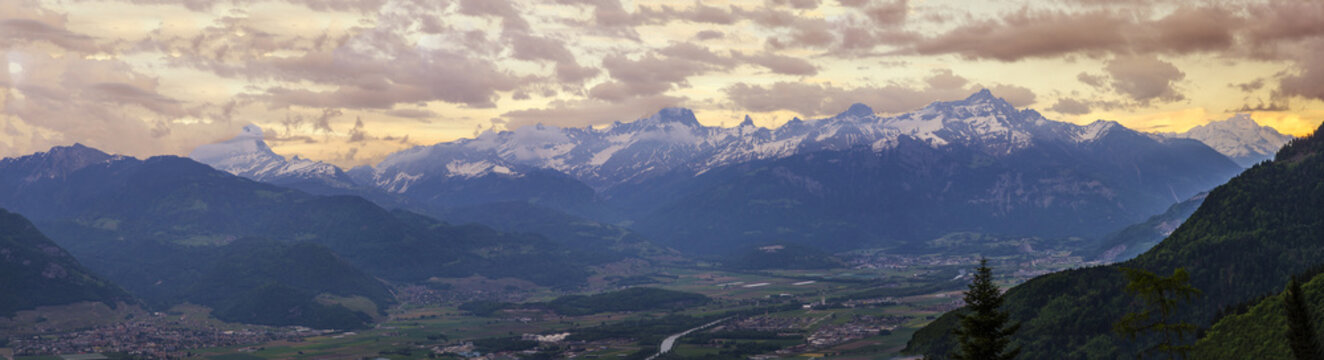 This fantastic panoramic image shows the Franco Swiss Alps in all the splendour. The beautiful Swiss Valais Valley  basks in the lustre of twilights glow. The Greffaz river meanders through the valley