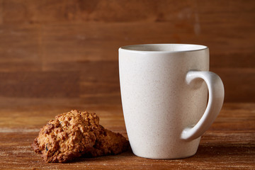 White porcelain mug of tea and sweet cookies on wooden background, top view, selective focus