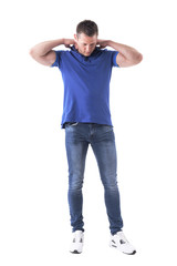 Young adult casual man put on blue polo shirt and looking down. Full body isolated on white background. 