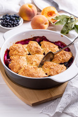 Freshly baked peach and blueberry cobbler. Homemade fruit pie.