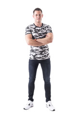 Fototapeta premium Happy relaxed smiling young adult man in army shirt with crossed arms looking at camera. Full body isolated on white background. 