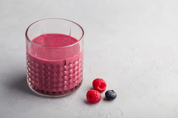 Mixed berry smoothie on light concrete background 