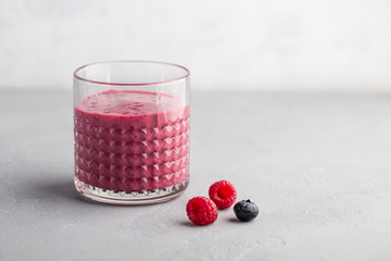 Mixed berry smoothie on light concrete background 