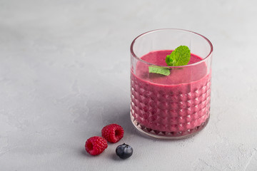 Mixed berry smoothie with mint on light concrete background 