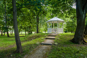 A pavilion in a beautiful garden park. White gazebo in the green summer park. Saka manor. Estonia.