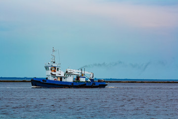 Blue tug ship underway