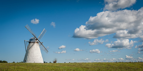 Stone windmill on background field and cloudy sky. Vihula, Estonia. Panoramic view.