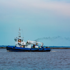 Blue tug ship underway