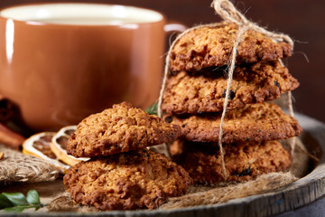 Traditional Christmas tea concept with a cup of hot tea, cookies and decorations on a wooden background, selective focus