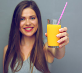 Happy smiling woman holding glass with orange guice.