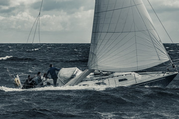 Blue sailboat at storm