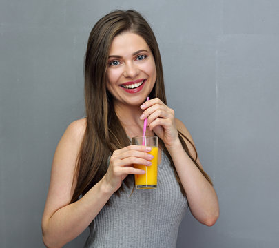 Smiling woman holding orange juice glass.