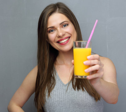 Smiling woman holding orange juice glass.