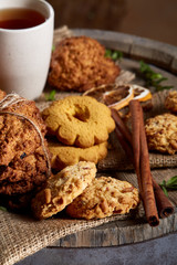 Traditional Christmas tea concept with a cup of hot tea, cookies and decorations on a wooden background, selective focus