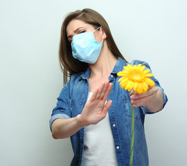 Stop allergy concept with woman holding yellow flower.