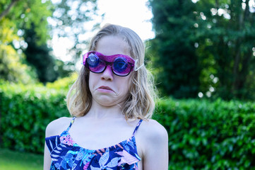 Portrait of a female child with some home made glasses over her real glasses