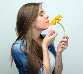 Young woman sniffing yellow flower.
