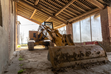 Fototapeta na wymiar photograph of a scraper parked in the farmhouse.farmhouse